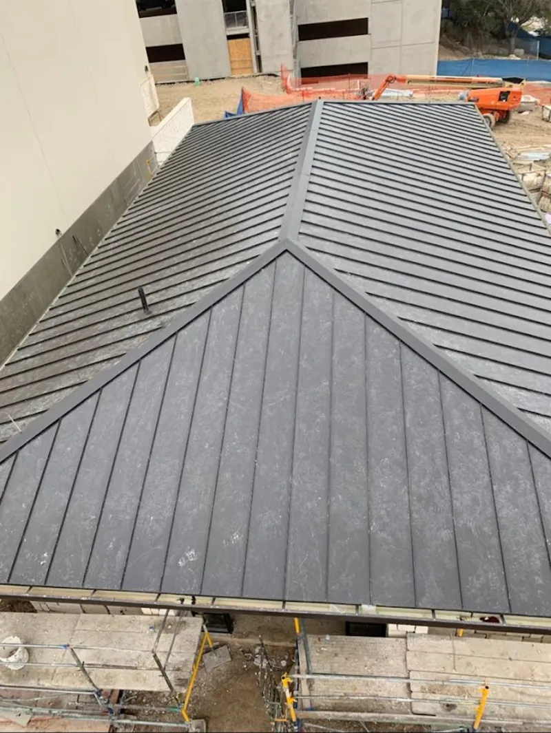 Commercial metal roof construction with crane equipment in New London